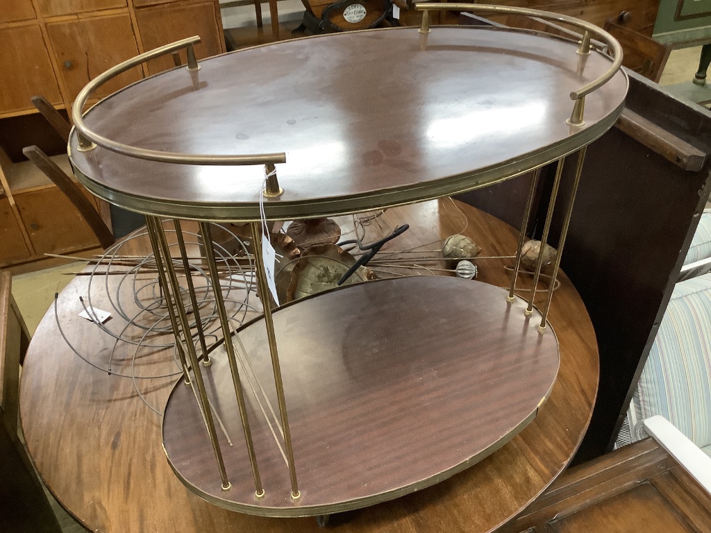 A brass mounted simulated rosewood oval two tier tea trolley, c.1970, width 70cm depth 45cm height 68cm